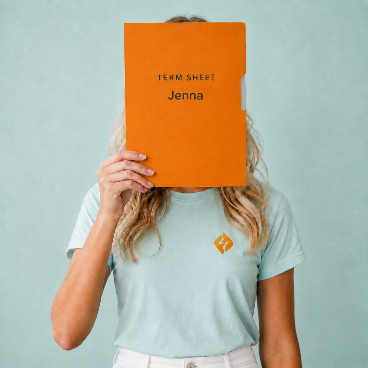 Founder holding an orange term sheet folder in front of her face
